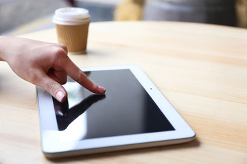 Woman working with tablet in cafe