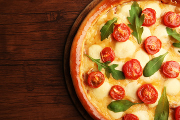 Pizza Margherita with arugula on wooden background