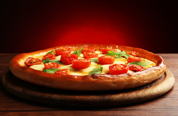 Pizza Margherita with arugula on dark red background