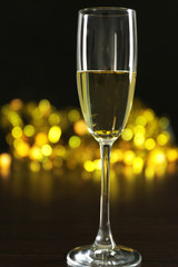 A glass of champagne with bokeh on dark background
