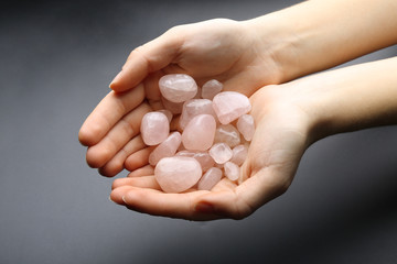 Woman holding semiprecious stones in her hands on dark grey background