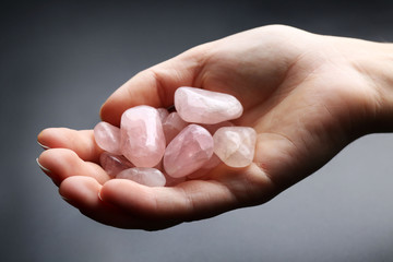 Woman holding semiprecious stones in her hand on dark grey background