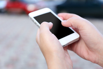 Woman holding smartphone outside