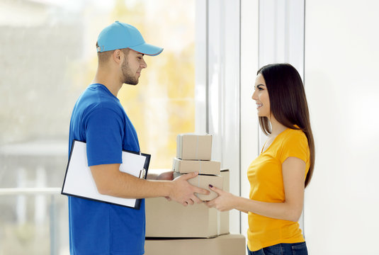 Receiving parcel - delivery man gives package to young woman
