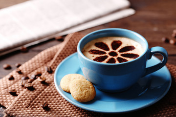 Cup of coffee  and fresh newspaper on wooden table background