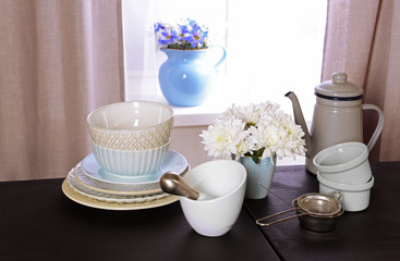 Kitchenware on table on window background