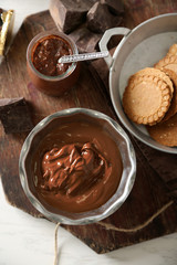 Melted chocolate in bowl, on wooden background