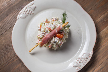 Russian traditional salad olivier with pea in the plate 