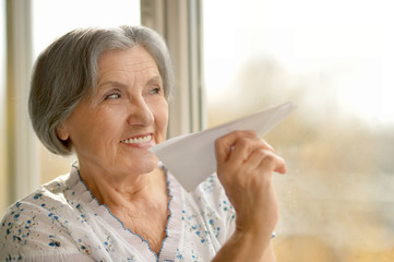 Senior woman with paper plane