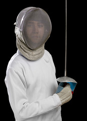 Cropped image of a foil fencer on black background.