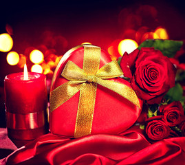 Valentine gift box and rose flower on red silk background