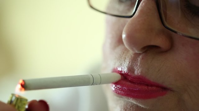 Senior woman with a cigarette. Female smoker, close up shot