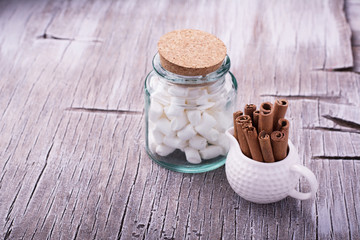 Cinnamon sticks in bucket on wooden background