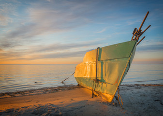 Anchored fishing boat on sandy beach of the Baltic Sea
