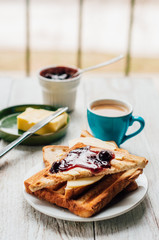 Breakfast with coffee, toasts, butter and jam