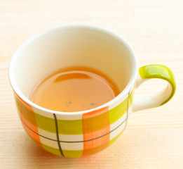 Cup of tea on bright wooden background