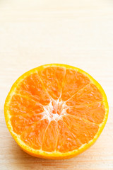 Glass of orange juice with orange slice on soft wooden background