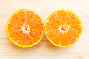 Glass of orange juice with orange slice on soft wooden background