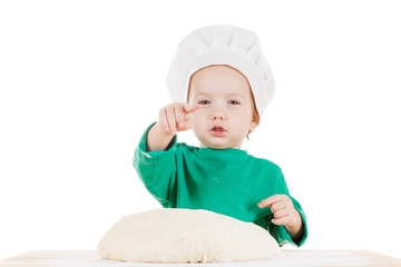 Serious little boy kneading dough for the cookies, isolated on white