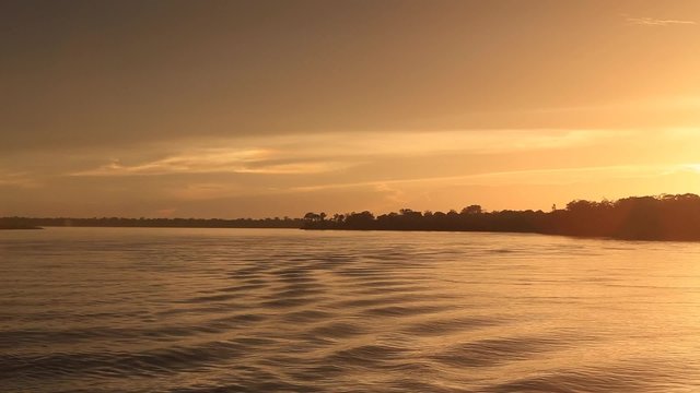 Wonderful panoramic colored sunset on the large river Amazon with ripples. Amazonas State, Brazil