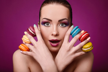 Obraz na płótnie Canvas Beauty glamor fashion model girl with colourful makeup and macaroons.