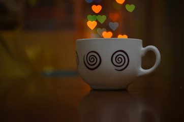 cup of coffee on the background bokeh in the form of hearts. Background to the Valentine's day