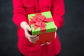 Female hands holding gift with ribbon.