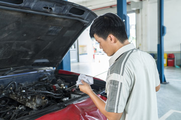 Auto mechanic oil checking engine oil level. Car repair service