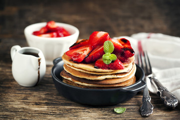 Stack of pancakes with fresh strawberry and balsamic glase in fr