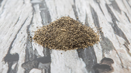Black pepper powder over wooden background