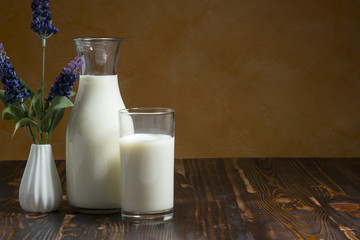Milk bottle and milk glass put on wooden table.