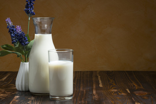 Milk bottle and milk glass put on wooden table.