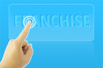 Obraz na płótnie Canvas touching FRANCHISE sign on blue screen