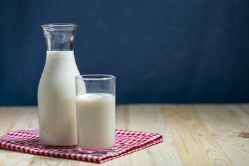 Milk bottle and milk glass put on wooden table.