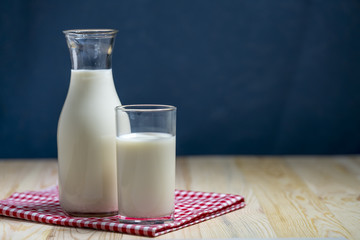 Milk bottle and milk glass put on wooden table.