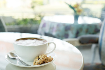 A cup of coffee in a white cup on mable table