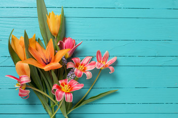 Yellow and red tulips flowers  on turquoise  painted wooden plan