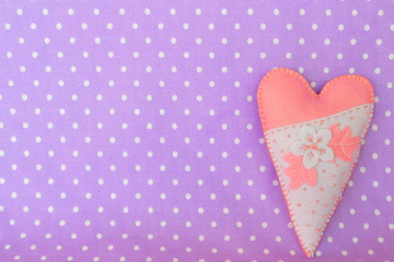 Handmade felt heart - symbol of Valentines Day, on violet background, with place for text