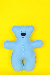 Handmade felt bear - bluу felt bear on yellow background, hand-stitched toy