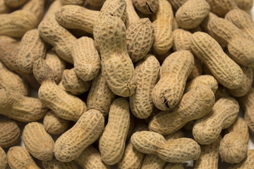 This is a photograph of salted and roasted peanuts in the shell