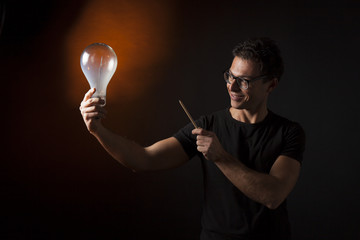 Ragazzo indica con una matita una lampada: concetto di idea, innovazione, genialità