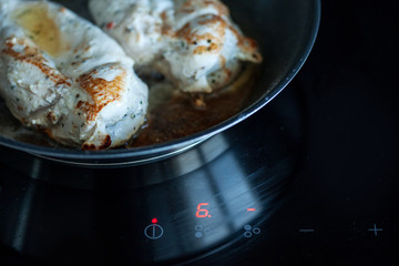 Cooking at home, chicken fillet with tomato, cooking pan, induction cooker