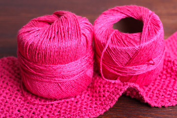  pink yarn for knitting on the wooden background closeup