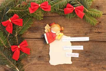 Christmas background with ribbon on fir tree over a textured background with merry Christmas text and angel - Merry Christmas lettering
