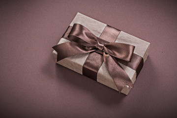 Wrapped present box on brown background holidays concept