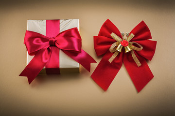 Wrapped present box red bow on golden background holidays concep