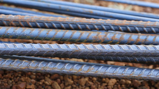 Panning shot of steel rods or bars used to reinforce concrete for construction