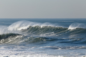 Long spraying wave in a sunny day