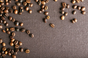 Fototapeta na wymiar Roasted coffee beans on grey textile background