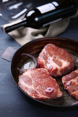 Marbled beef steak and wine bottle on wooden background
